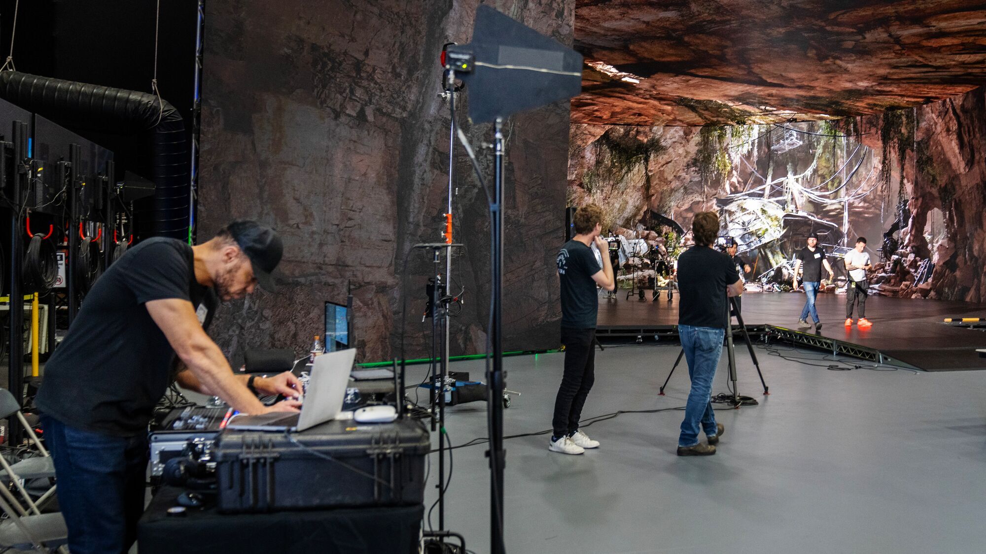 Film crew working in front of a cave environment on the Stage 15 LED volume